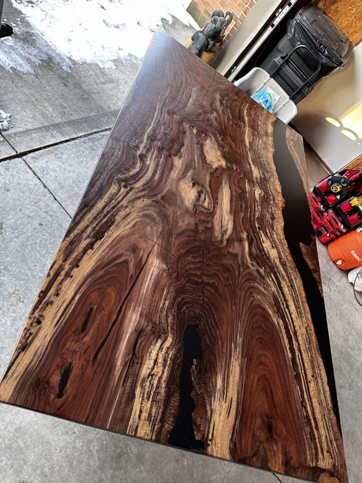 Close view of flowing figure across the walnut tabletop